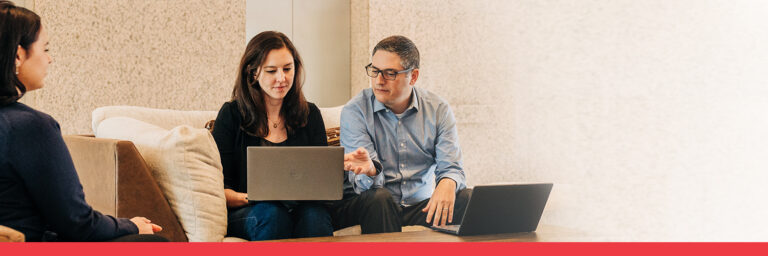 3 individuals seated at a table working